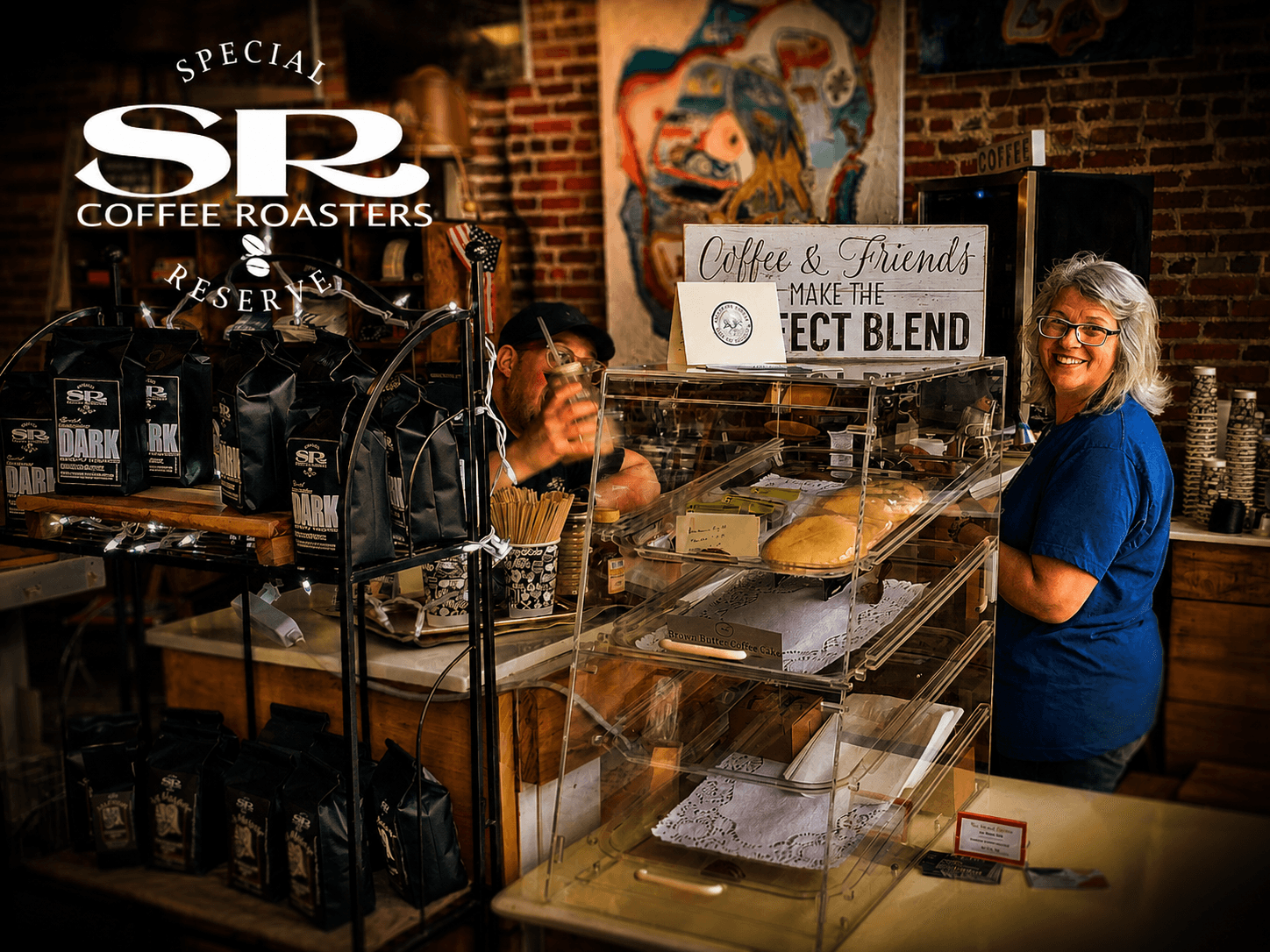 Donna Anderson and a team member behind the counter at the Special Reserve Coffee Roasters shop, surrounded by bagged coffee and pastries