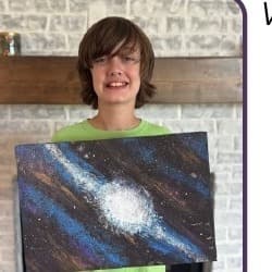 Relic, a Shriners Children's Shreveport patient, holding his galaxy-themed painting